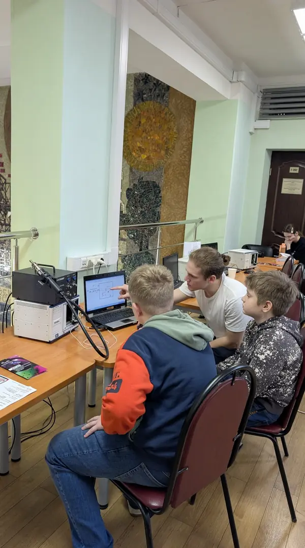 Преподаватель показывает ребятам схему на экране ноутбука
